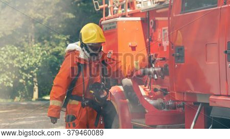 Firefighter Fighting With Flame Using Fire Hose Chemical Water Foam Spray Engine. Fireman Wear Hard
