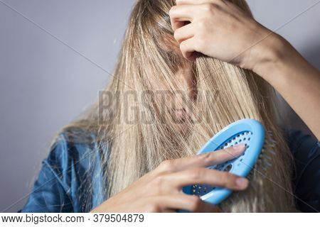 Blonde Combs Her Hair After Shampooing. On A Gray Background. Clean Dry Hair, Healthy, No Problem, C