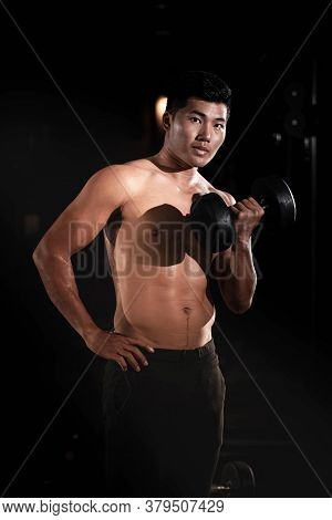 Handsome Man Raising Dumbbell,doing Exercise For Buit Muscle,fit And Firm Body,model Posing