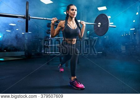 Gorgeous Brunette Female With Long Braids Doing Squats Using Barbell. Side View Of Srtong Concentrat