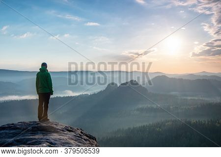 Motivation And Inspiration In Beautiful Sunset Landscape. Female Hiker With Hands In Pocket  On Moun