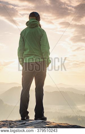 Motivation And Inspiration In Beautiful Sunset Landscape. Female Hiker With Hands In Pocket  On Moun