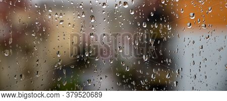 Rain Drops Falling On The Window. Blurred Residential Area In Background.