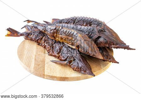 Smoked Sterlet Or Sturgeon Fish. Smoked Dilicates Sterlet Sturgeon Fish On A Wooden Board. Few Smoke
