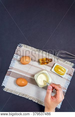 Homemade White Sauce Mayonnaise And Ingredients Eggs, Lemon Olive Oil On Black Background. Top View