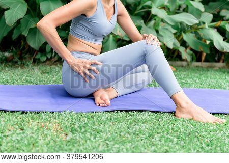 Woman Using Her Hands To Massage The Thigh In Order To Relax The Muscles After Her Exercise By Playi