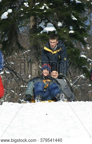 ZAGREB, CROATIA - JANUARY 12, 2014: Landscape view of a snowy hill with families with children and people sledging and having fun in snow, Park Maksimir in Zagreb, Croatia