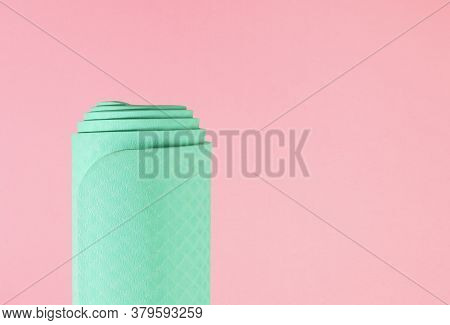 Rolled Yoga Gym Mat Isolated Against A Pink Baclground, Health And Fitness Concept With Copy Space