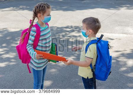 Back To School. Brother And Sister Or Boy And Girl Wearing Protective Medical Masks In The Schoolyar