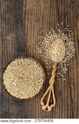 Puffed quinoa grain health food in a bowl and lovespoon. Highly nutritious rich in fibre, antioxidants, protein, with a low GI for blood sugar control for diabetics. Flat lay on rustic wood.