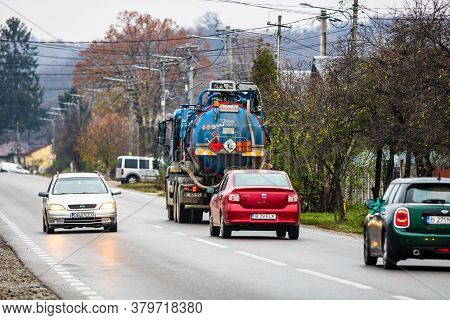 Cars On The Asphalt Road. Utility Car (from Rohrer Group Company) In Traffic.  Targoviste, Romania, 