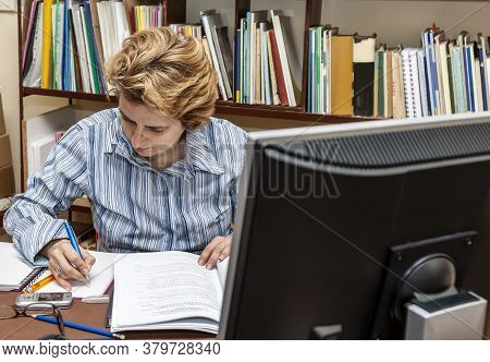 Image Of A Busy Woman Teleworking At Her Desk At The Home. Working At Home Became An Important Recom
