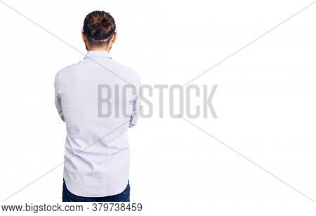Young handsome man wearing business clothes standing backwards looking away with crossed arms 