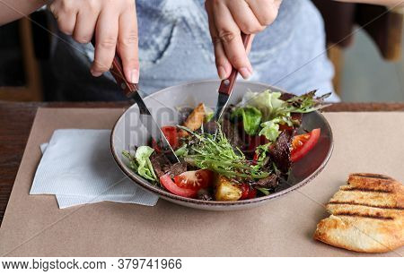 Woman Eating Healthy Salad With Beef, Vegetables, Herbs In Cafe