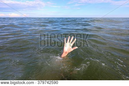 Hand Of The Person Asking For Help While Drowning In The Middle Of The Sea