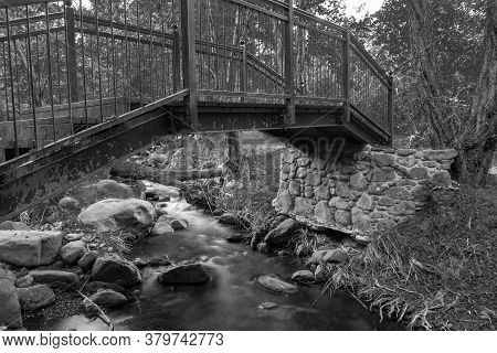 Bridge Over Smooth Flowing Water Stream At The Vateri Footpah In Kakopetria, Troodos, Cyprus