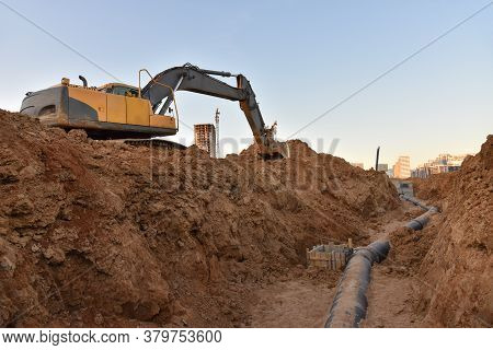 Excavator Dig The Trenches At A Construction Site. Trench For Laying External Sewer Pipes. Sewage Dr