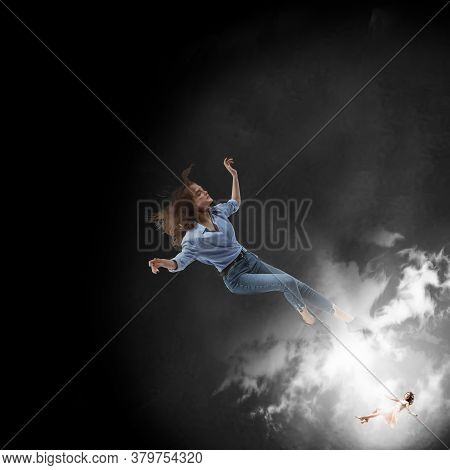 Mid-air Beauty Cought In Moment. Full Length Shot Of Attractive Young Woman Hovering In Air And Keep