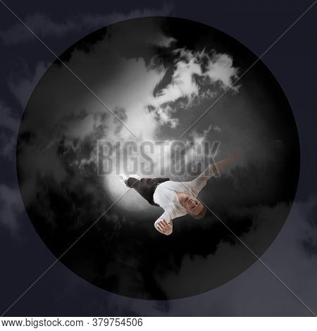 Mid-air Beauty Cought In Moon Light. Full Length Shot Of Young Man Hovering In Air And Keeping Eyes 