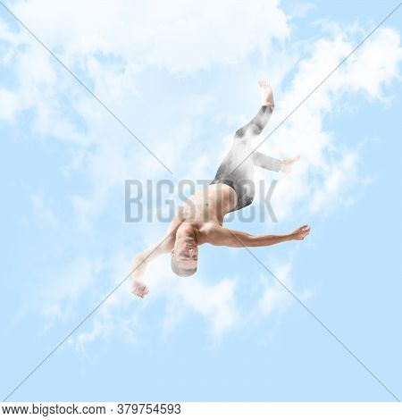 Mid-air Beauty Cought In Sky. Full Length Shot Of Young Man Hovering In Air And Keeping Eyes Closed.