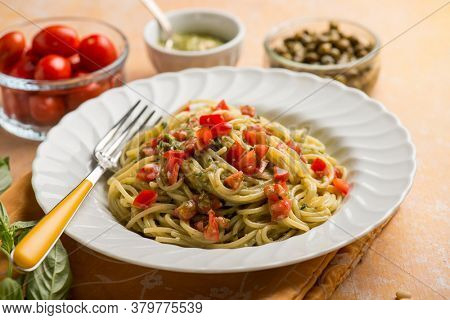 spaghetti with pesto sauce tomatoes fres and capers