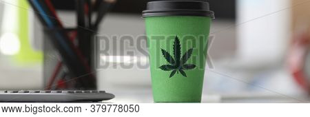 On Table Is A Paper Cup With Lid Painted Hemp. Legalized Stand-alone Drink With Hemp. Flavored Organ