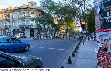 Odessa, Ukraine - August 4, 2020: Preobrazhenskaya street near the Cathedral square and city Park, green trees and people, road with car traffic