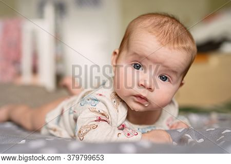 Newborn Baby Lies On His Stomach, Keeps His Head On Weight, Drooling, Droplets Are Visible On  Lips