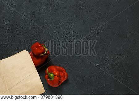 Two Ugly Red Peppers With A Paper Bag On A Black Background With Space