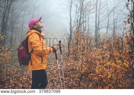 Dressed Bright Orange Jacket Young Female Backpacker Enjoying The Nature. She Walking In Autumn Fogg