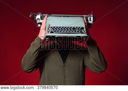 Man Holding A Typewriter On Red Background