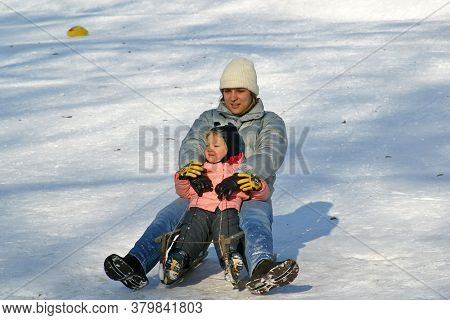 ZAGREB, CROATIA - JANUARY 12, 2014: Landscape view of a snowy hill with families with children and people sledging and having fun in snow, Park Maksimir in Zagreb, Croatia