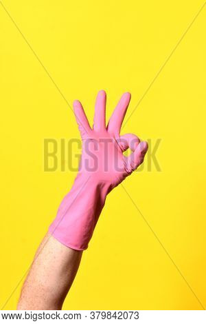 Hand With Glove And Ok Sign On Yellow Background