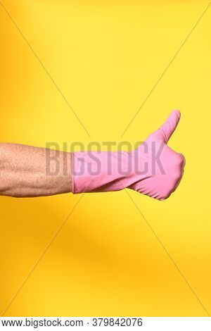 Hand With Glove And Thumbs Up On Yellow Background