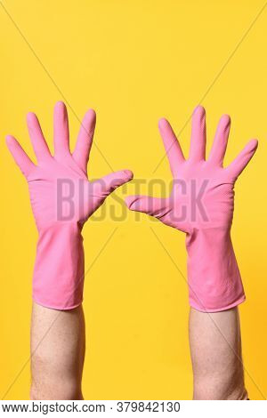 Gloved Hands Raised On A  Yellow Background