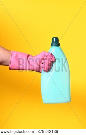 Hand With Glove And Plastic Bottle Soap On Yellow Background