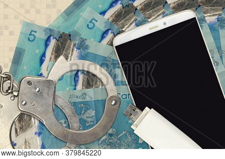 5 Canadian Dollars Bills And Smartphone With Police Handcuffs. Concept Of Hackers Phishing Attacks, 