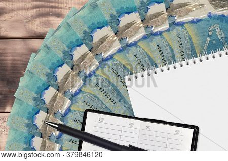 5 Canadian Dollars Bills Fan And Notepad With Contact Book And Black Pen. Concept Of Financial Plann