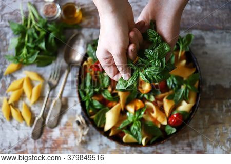 Hands Of A Chef With Basil For Cooking Italian Pasta. Cooking One Pan Pasta.