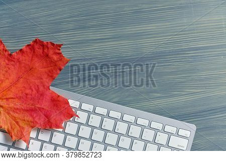 Autumn Concept With Leaves And Keypad Copace On A Wooden Background.