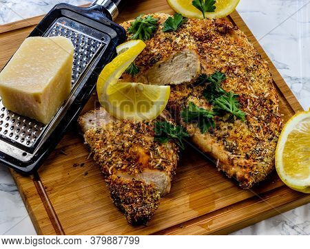 Itailain Bread Chicken With Fresh Lemon On A Wooden Cutting Board. Calgary, Alberta, Canada