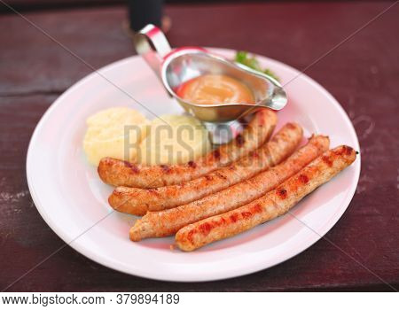 Dish With Bavarian Sausages And Mashed Potatoes With Sauces
