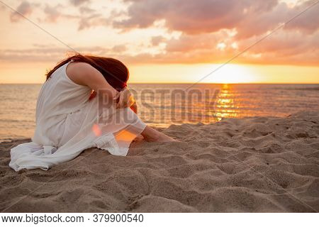 Profile Of A Single Alone Or Divordes Woman Silhouette In Long White Dress Sitting On The Beach At S