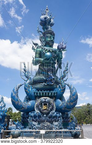 Chiangrai, Thailand - June 7, 2020: Blue God Statue Hold Lotus And Ball On Blue Sky Background With 