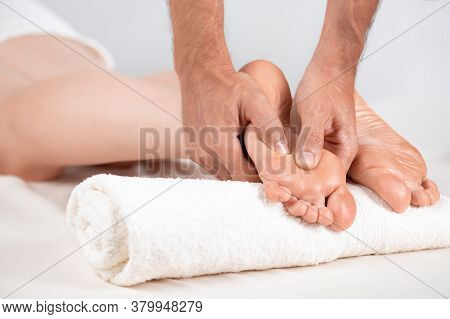 The Masseur Massages The Pads Of The Feet Of The Girl Who Is Lying On The Massage Table. Very Close-