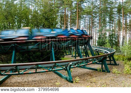 Ride Roller Coaster In Motion In Amusement Park At Summer Day