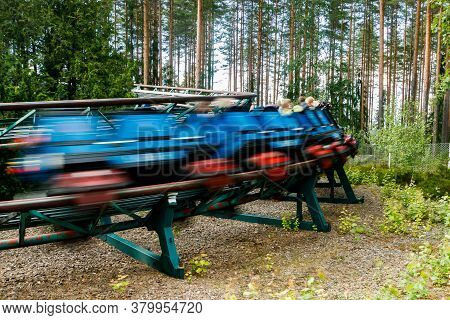 Ride Roller Coaster In Motion In Amusement Park At Summer Day