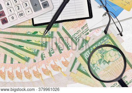 10 Sri Lankan Rupees Bills And Calculator With Glasses And Pen. Tax Payment Season Concept Or Invest