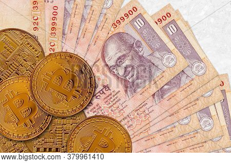 10 Indian Rupees Bills And Golden Bitcoins. Cryptocurrency Investment Concept. Crypto Mining Or Trad