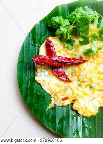 Omelette With Coriander Leaves And Red Chillies In A Banana Leaf.the Banana Leaf Has Green Color And